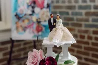 bride and groom wedding topper on top of a wedding cake