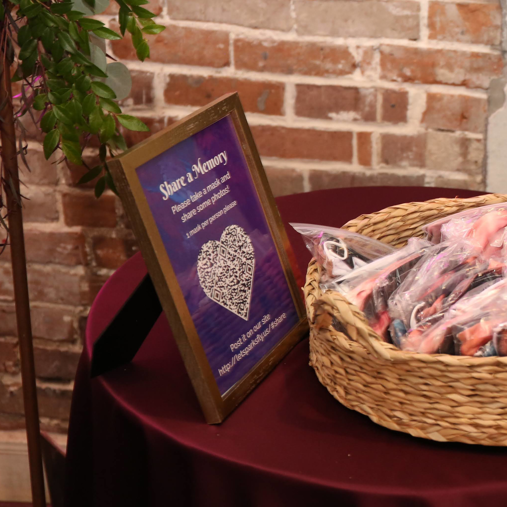 Framed “Share a Memory” sign with a heart-shaped QR code encouraging guests to post photos and messages
